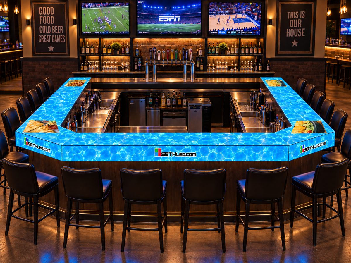 The same bar seen head on, its whole top a lit LED surface running rippling blue water with food photography set into it.